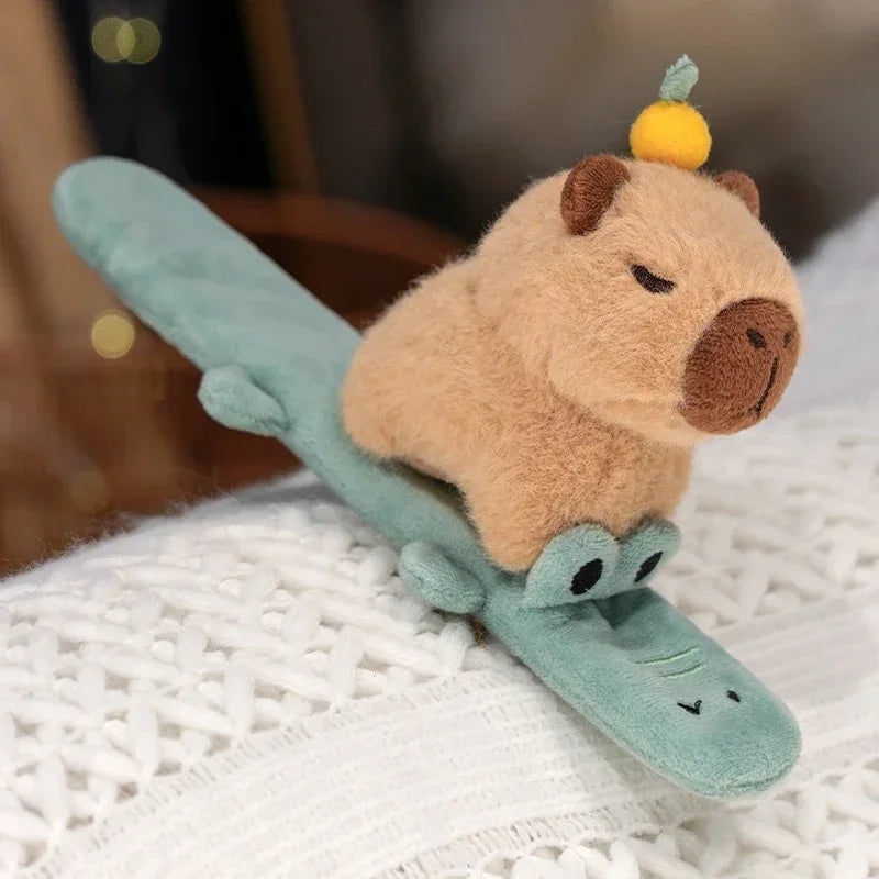 Porte-clé capybara peluche avec une orange sur la tête, à enrouler au poignet